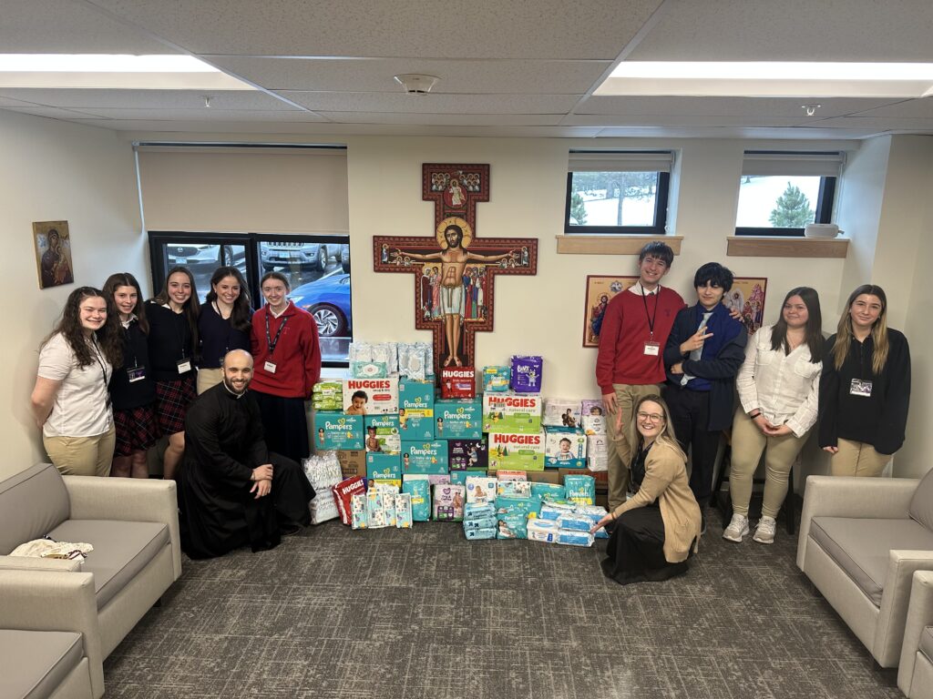 A picture of teenagers and boxes of donated diapers