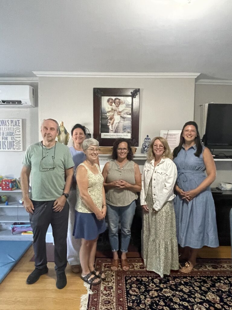Picture of 6 peopel standing in front of a fireplace